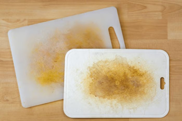 Two white plastic cutting boards stained orange-brown across the cutting surface